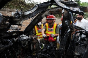 Pakistani rescuers inspect the badly damaged US consulate vehicle at a bomb blast site in Peshawar  AFP PHOTO / A MAJEED 