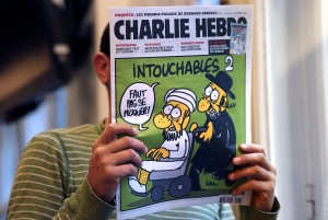 A man reads  the back cover of French satirical weekly Charlie Hebdo which features on the front covera satirical drawing titled "Intouchables 2". Inside pages contain several cartoons caricaturing the Prophet Mohammed  AFP PHOTO / THOMAS COEX