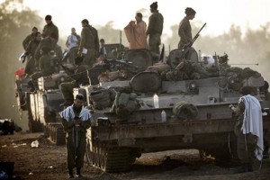 sraeli soldiers wearing "Talit" (prayer shawls) conduct morning prayers at an Israeli army deployment area near the Israel-Gaza Strip border on 20 November. (AFP PHOTO / MENAHEM KAHANA)