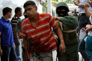 A Venezuelan army soldier leads a prisoner wounded during a riot in the Uribana prison on January 25, 2013 (Diario el Impulso/AFP, Dedwinson Alvarez)