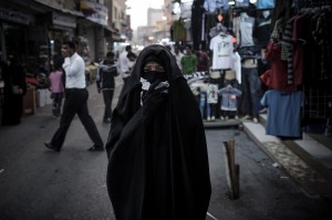 A Bahraini woman protects herself from tear gas fired by riot police during an anti-regime rally in solidarity with jailed human rights activist Nabeel Rajab and against the upcoming Bahrain Formula One Grand Prix in Manama  (AFP Photo)