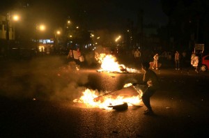 Egyptian anti government protesters walk through burning cardboards during clashes between the April 6 movement supporters and police outside the High Court on April 6, 2013 in Cairo (AFP Photo)